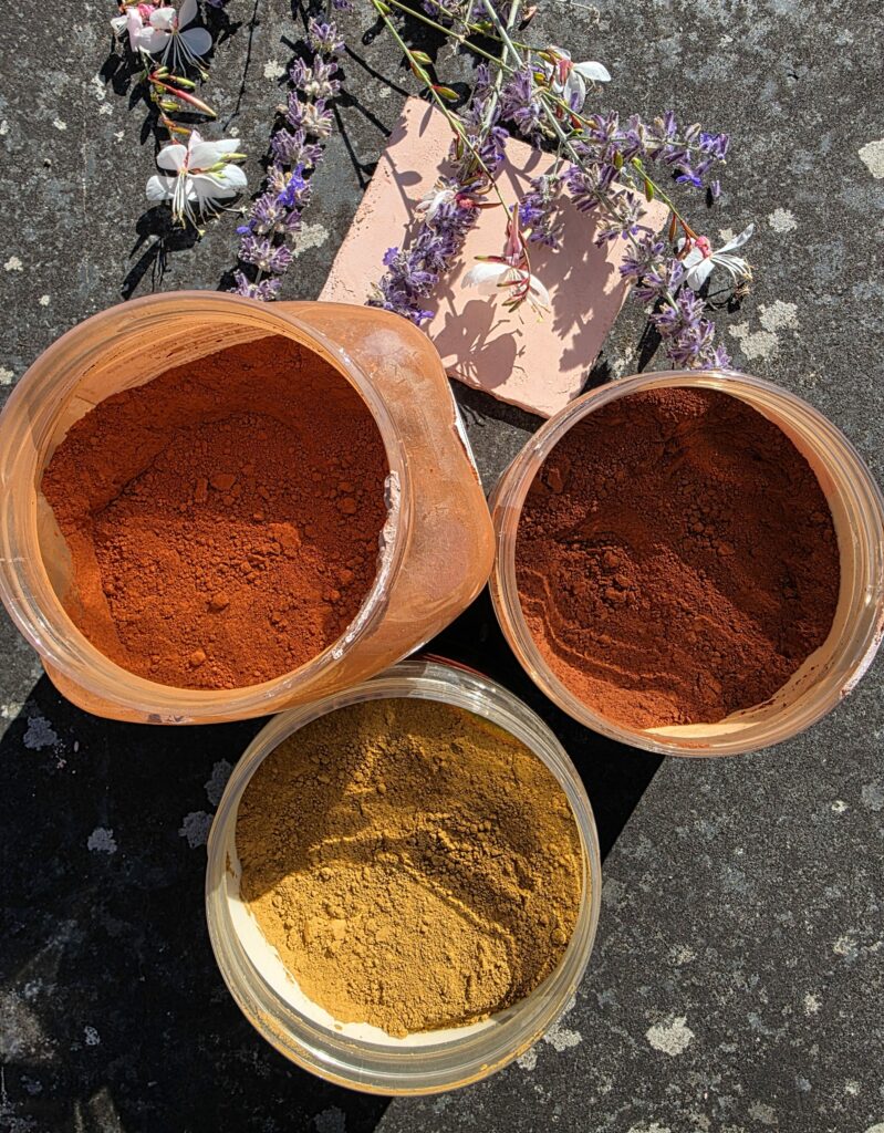 Accueil Trois pots de pigments naturels aux teintes ocre jaune, rouge et terre cuite pour la réalisation d'enduits décoratifs.