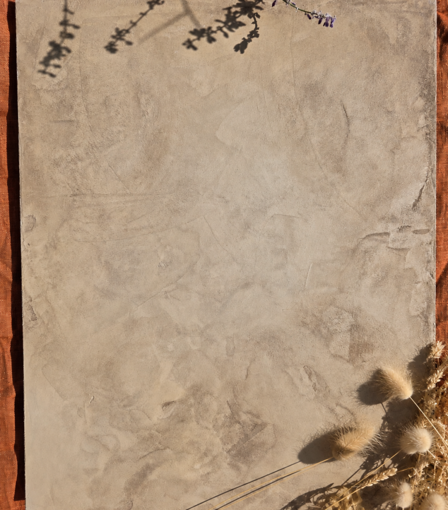 Mes prestations Gros plan sur un enduit décoratif mural aux nuances beige et gris, avec une finition texturée et des effets de matière.